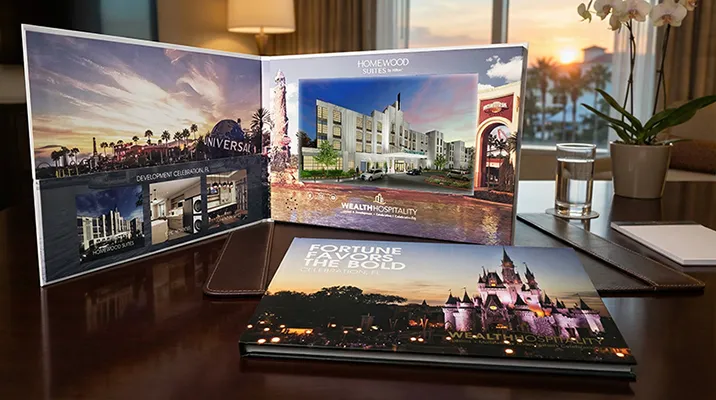 Video brochure showcasing hotel images and promotional text on a table.